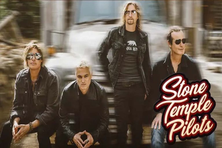 Foto promocional da banda Stone Temple Pilots com os quatro integrantes vestindo roupas escuras, posando em frente a um caminhão desfocado ao fundo. O logotipo da banda aparece no canto inferior direito.