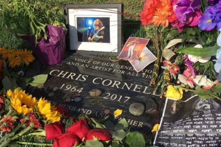 Foto do túmulo de Chris Cornell no cemitério Hollywood Forever, cercado por flores e homenagens de fãs.