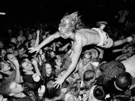 Fã surfando na multidão durante show nos Anos Dourados do Grunge.