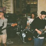 Banda de rock alternativa em ambiente urbano com grafite, mantendo viva a estética do grunge.