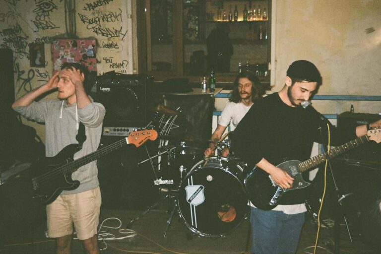 Banda de rock alternativa em ambiente urbano com grafite, mantendo viva a estética do grunge.