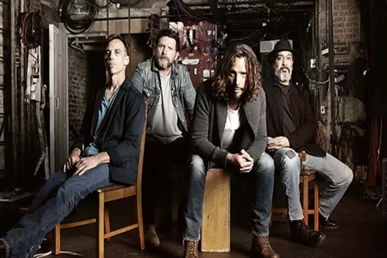 Banda Soundgarden reunida em ambiente rústico, com integrantes sentados, expressando atitude e autenticidade.