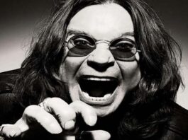 Ozzy Osbourne gritando com expressão intensa, usando óculos escuros e jaqueta de couro.