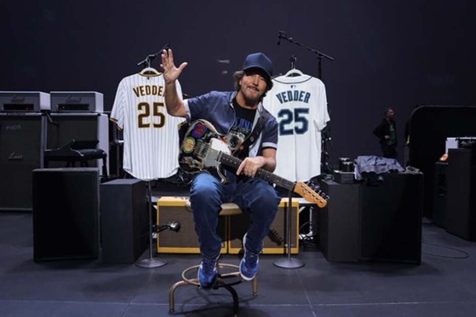 Eddie Vedder sentado com guitarra entre camisas dos Mariners e Padres no Vedder Cup.