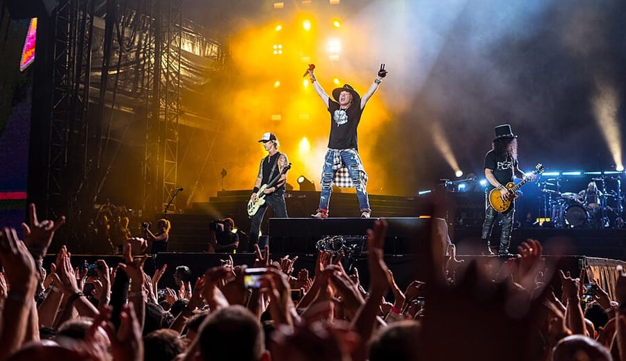 Show do Guns N' Roses com Axl Rose e Slash no palco diante de multidão, momento marcante na história do Guns N' Roses